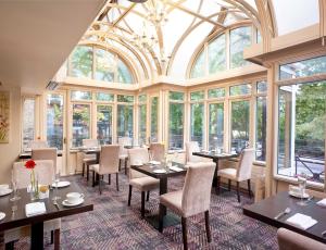 a dining room with tables and chairs and windows at Corus Hyde Park Hotel in London