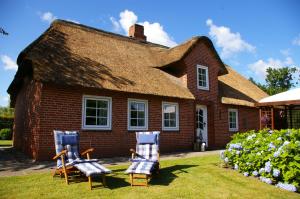 una casa con due sedie davanti di Ferienhaus Klookris 15 a Risum-Lindholm