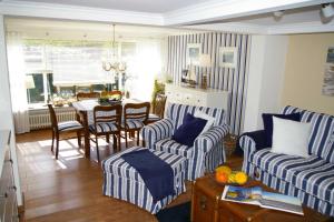 salon z niebiesko-białymi paskami i stołem w obiekcie Ferienhaus Klookris 15 w mieście Risum-Lindholm
