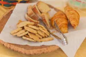 un piatto di pane e prodotti da forno e croissant su un tavolo di Residence Hotel Raggio Di Luce a Ponte di Legno