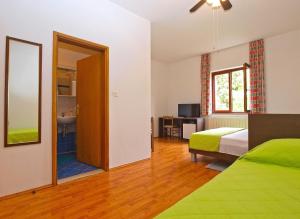 a bedroom with a bed and a mirror and a bathroom at Rooms Ivica 1452 in Fažana