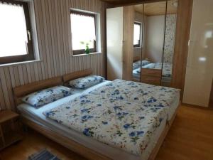 een slaapkamer met een bed met blauwe bloemen erop bij Ferienwohnung Jakob in Nohra