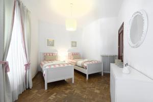 Habitación blanca con 2 camas y espejo. en Piso en calle Recogidas (Centro), en Granada
