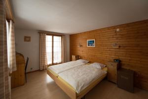 A bed or beds in a room at Hôtel des Haudères