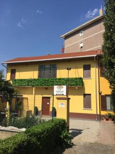 een geel gebouw met een bord ervoor bij Location Lory in Busto Arsizio