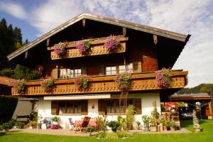 een huis met bloembakken op het balkon bij Ferienwohnung "Hüs 18" in Fischen