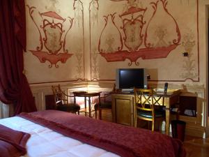 a bedroom with a bed and a table and a television at San Anselmo in Rome