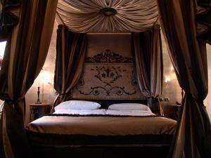 a bedroom with a canopy bed with curtains at San Anselmo in Rome