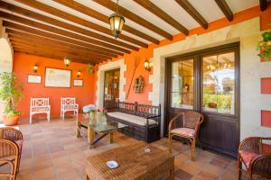 a porch with orange walls and a table and chairs at Posada Rio Cubas in Cubas