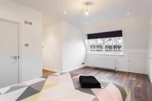 een witte kamer met een zwarte tas op een vloer bij Fleet Street Apartment 4 in Londen