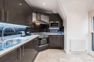 a kitchen with a sink and a stove at Fleet Street Apartment 4 in London