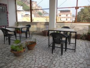 a patio with tables and chairs and potted plants at Raj Mahal Guest House in Būndi