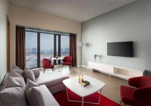 a living room with a couch and a tv at Sanya Phoenix Airport Hotel in Sanya