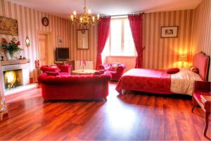 a bedroom with a bed and a couch and a fireplace at Chateau Le Val in Brix