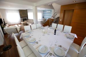 una sala da pranzo con tavolo bianco e sedie bianche di Villa Mastlo ad Assenta