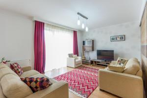a living room with two couches and a flat screen tv at City Apartment Trifoiului in Cluj-Napoca