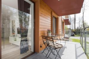 a balcony with a table and chairs on a house at Grace Apartment II in Kołobrzeg