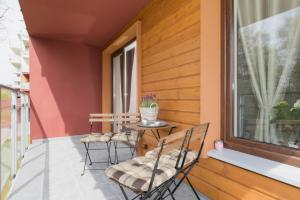 a balcony with a table and chairs and a window at Grace Apartment II in Kołobrzeg