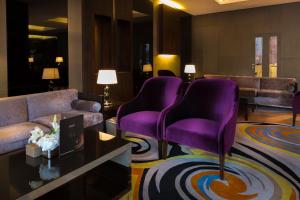 Park House في الرياض: غرفة معيشة مع كراسي أرجوانية وأريكة