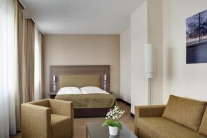 um quarto de hotel com uma cama e duas cadeiras em IntercityHotel Leipzig em Leipzig