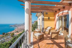 a balcony with chairs and a view of the ocean at Luxury One Bedroom Palheiro Village by HR Madeira in Funchal