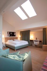 a large bedroom with a bed and a chair at Genießerhotel Döllerer in Golling an der Salzach