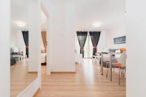 a living room with a table and a dining room at Grace Apartment II in Kołobrzeg