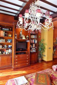 uma sala de estar com um lustre e uma televisão em Plaza San Francisco luxury apt em Sevilha