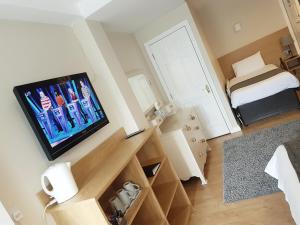 a small room with a television and a bed at Belfast House in Cookstown