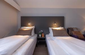 two beds sitting next to each other in a room at Enter Viking Hotel in Tromsø