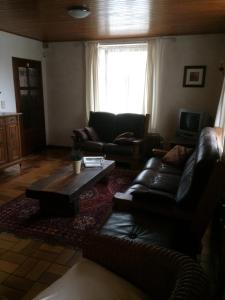 uma sala de estar com um sofá de couro e uma mesa de centro em Lin-La-Bedin em Vielsalm