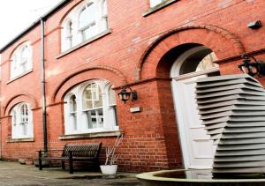 a brick building with a white door and a bench at Princes Dock Chambers 10 in Hull