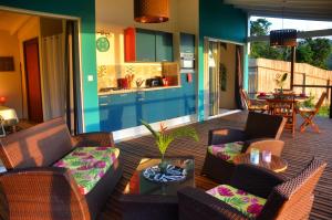 a living room with a couch and chairs and a kitchen at Du Côté de Chez Swann in Deshaies