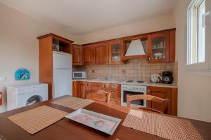 a kitchen with a table and a white refrigerator at Athena Villa in Kolimbia