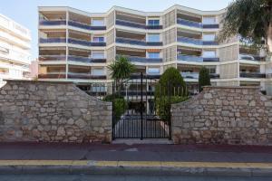 un edificio con un cancello di fronte a un muro di pietra di Appartement Cannes vue mer a Cannes