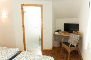 a bedroom with a desk with a computer and a chair at Wambacher Mühle in Schlangenbad