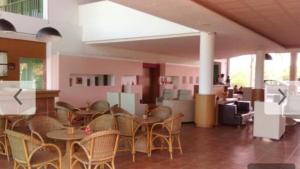 ein Esszimmer mit Stühlen und Tischen und ein Zimmer mit Personen in der Unterkunft Beach Class Muro Alto - flat in Porto De Galinhas