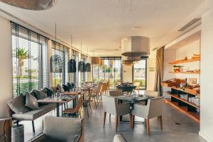 a restaurant with tables and chairs and windows at Lagos Avenida Hotel in Lagos