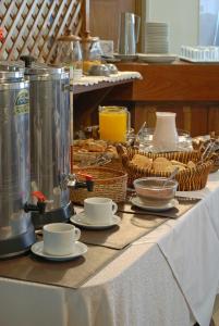 聖拉斐爾的住宿－Hotel San Rafael，桌子,上面有杯子,碟子和食物篮子