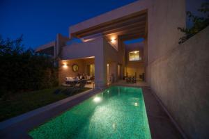 a swimming pool in front of a house at night at Villa Loubane in Marrakesh