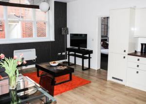 a living room with a table and a television at Princes Dock Chambers 2 in Hull