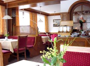 - une salle à manger avec une table, des chaises et une table dans l'établissement Pension Vier Jahreszeiten, à Saalbach-Hinterglemm
