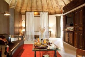 ein Wohnzimmer mit einem Ledersofa und einem Tisch in der Unterkunft Hotel Les Cinq Djellabas in Douar Caïd Layadi