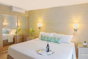 a bedroom with a large white bed with a tray on it at Bougainvillea Barbados in Christ Church
