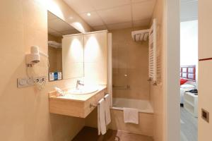 a bathroom with a sink and a shower and a mirror at Hotel Santa Rosa, Blue Hoteles in Gijón +37 photos