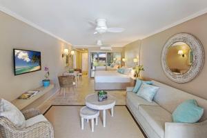 a living room with a couch and a bed at Bougainvillea Barbados in Christ Church