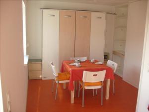 une salle à manger avec une table rouge et des chaises blanches dans l'établissement Am Jakobusweg App3, à Bamberg