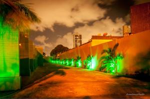 eine Straße mit grüner Beleuchtung an der Seite eines Gebäudes in der Unterkunft Toulouse Motel (Adult Only) in Natal