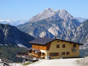 a house with a mountain in the background at Rifugio Col de Varda in Misurina