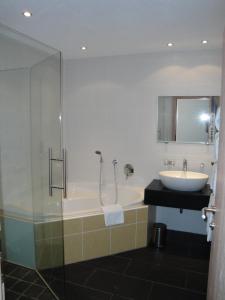 een badkamer met een bad, een wastafel en een douche bij Ferienwohnungen Vier Jahreszeiten in Längenfeld